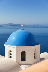 Fototapeta na wymiar Blue dome church in Oia, Santorini, Greece. Sea and volcano on b