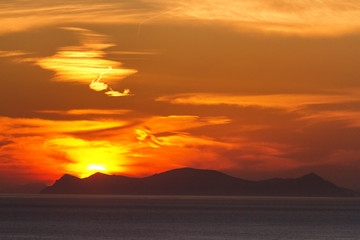 Naklejka na ściany i meble Sunset on a cloudy day in Oia, Santorini, Greece