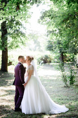 beautiful and young bride and groom standing together in the par