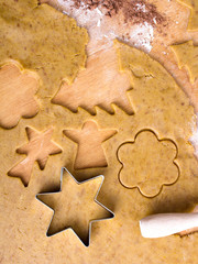 Cookies forms and gingerbread dough on wooden pastry board