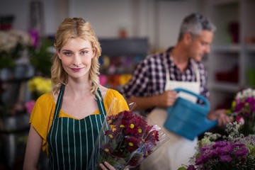 Happy female florist holding flower bouquet