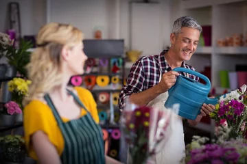 Crédence de cuisine en verre imprimé Fleuriste Fleuriste souriante arrosant des fleurs