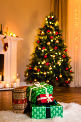 New year presents on a furry white carpet opposite a nicely decorated christmas tree. Christmas and Winter Holidays Background. Close up of Christmas presents, copy-space.
