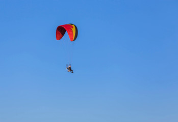 paraglider flying with paramotor on  blue sky  background
