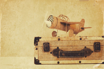 Photo of vintage yellow toy plane and old suitcase