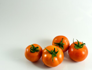 Four fresh tomatoes on white background. Organic vegetable for healthy eating.