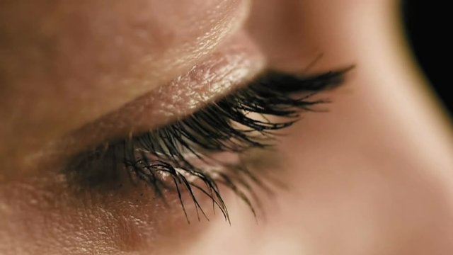 Female woman's eyes closeup side view slow motion.