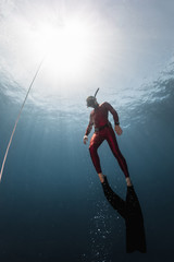 Underwater shot of the ascending free diver. Free immersion discipline