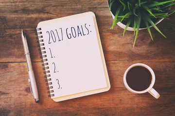 Top view 2017 goals list with notebook, cup of coffee