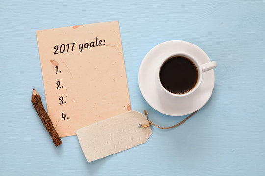 Top view 2017 goals list with notebook, cup of coffee
