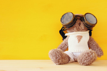 cute teddy bear with pilot glasses on wooden table