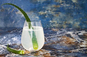 Sparkling cucumber mint gin and tonic fizz with aloe vera on marble table. Copy space. Dragon tail cocktail for fans party