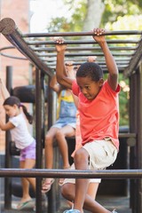 Obraz premium Schoolboy hanging on monkey rack