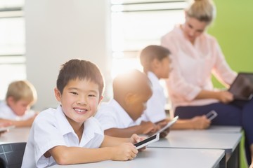 School kids using mobile phone in classroom