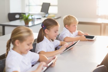 School kids using digital tablet in classroom