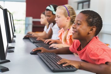 School kids using computer in classroom - Powered by Adobe