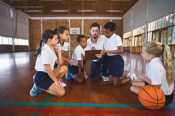 Sport teacher and school kids discussing