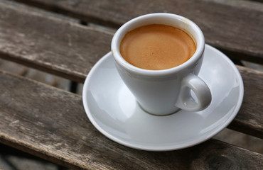 Espresso coffee in white cup close up on table