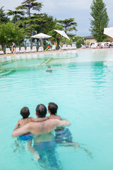 Young boy kid child splashing in swimming pool having fun leisur