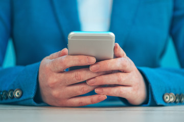 Businesswoman using smartphone, close up of hands