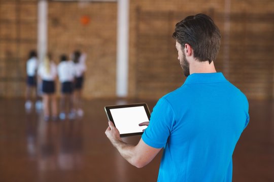 Sports teacher using digital tablet - Powered by Adobe
