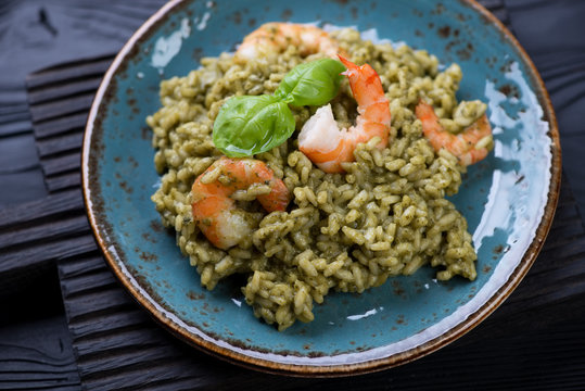 Closeup of freshly cooked risotto with spinach and tiger shrimps