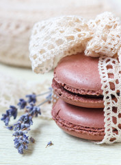 pastel colored macaroon with vintage lace ribbon bow and lavender on paper background