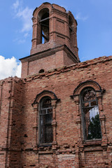 Fototapeta na wymiar A ruined church. Part of brick wall and bell tower.