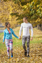 Beautiful young couple walking together in the park. Autumn environment.