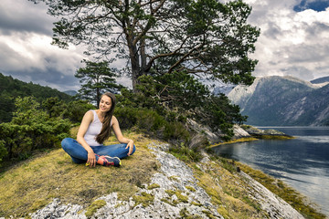 Fototapeta premium Young and sporty woman posing on the rocks, Norway