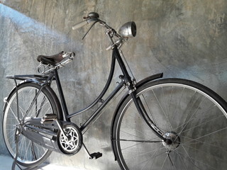 Fototapeta na wymiar Classic bike,Bicycle vintage style on Concrete wall in dark tone.