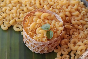Raw small yellow macaroni pasta for cooking.