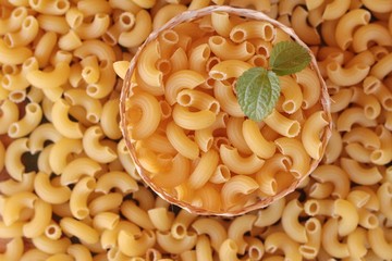 Raw small yellow macaroni pasta for cooking.