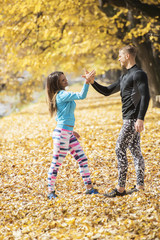 Beautiful young couple celebrate after successful running in the park. Autumn environment.