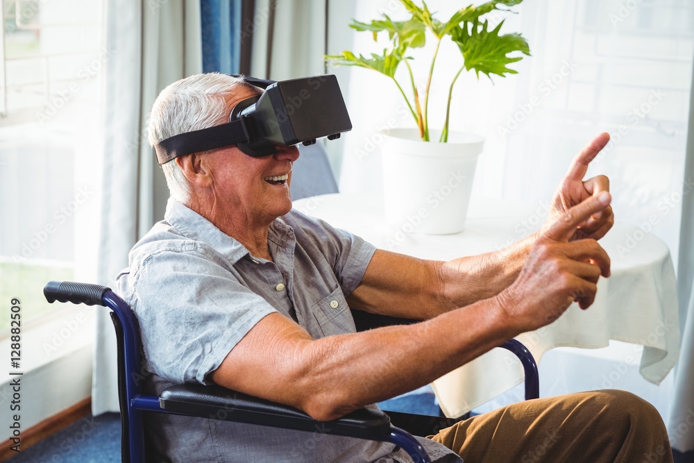 Wall mural senior man in a wheelchair using a virtual reality device
