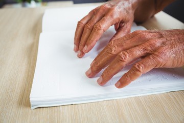 Senior man using braille to read