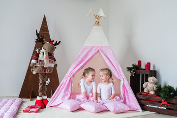 Two little girls play in a teepee