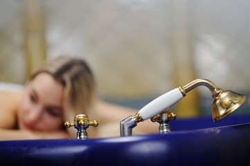 Junge Frau in einem Hamam, auf einem Tisch für die Schaummassage liegend