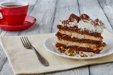 Tiramisu cake with walnuts and coffee on a wooden background