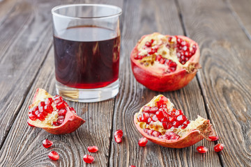 Ripe pomegranates with juice on a wooden table