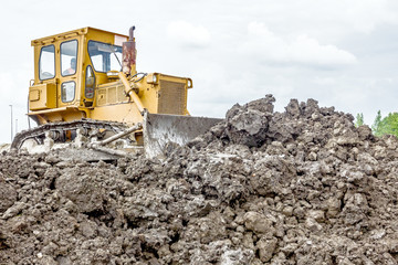 Obraz premium Heavy earthmover construction machine is moving earth at buildin