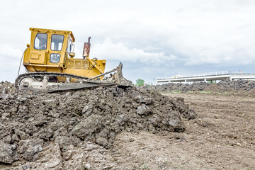 Heavy earthmover construction machine is moving earth at buildin
