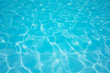 Fototapeta na wymiar Beautiful ripple water surface with sun reflection in swimming pool