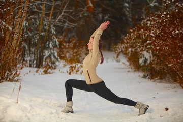 Fototapeta na wymiar beautiful woman doing yoga outdoors in snow