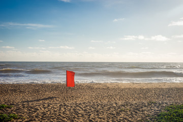Красный флаг на пляже.
