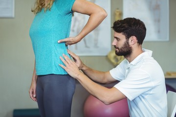 Physiotherapist examining womans back 
