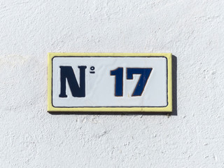 Street sign reading the number seventeen.