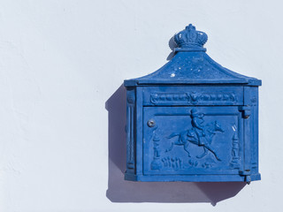 Blue aquamarine antique post box at a house wall.