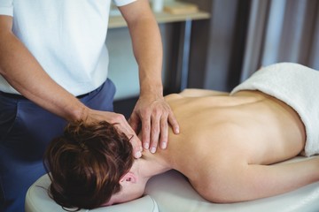 Obraz na płótnie Canvas Physiotherapist giving neck massage to a woman