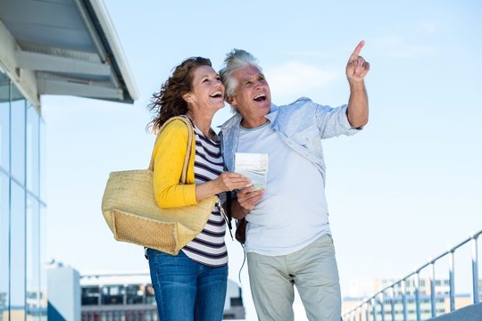 Joyful couple looking away against sky